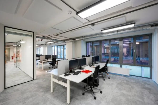 Moderne kantoortuin aan de Harry Banninkstraat met werkplekken, bureaustoelen en computers in een open ruimte met grote ramen.